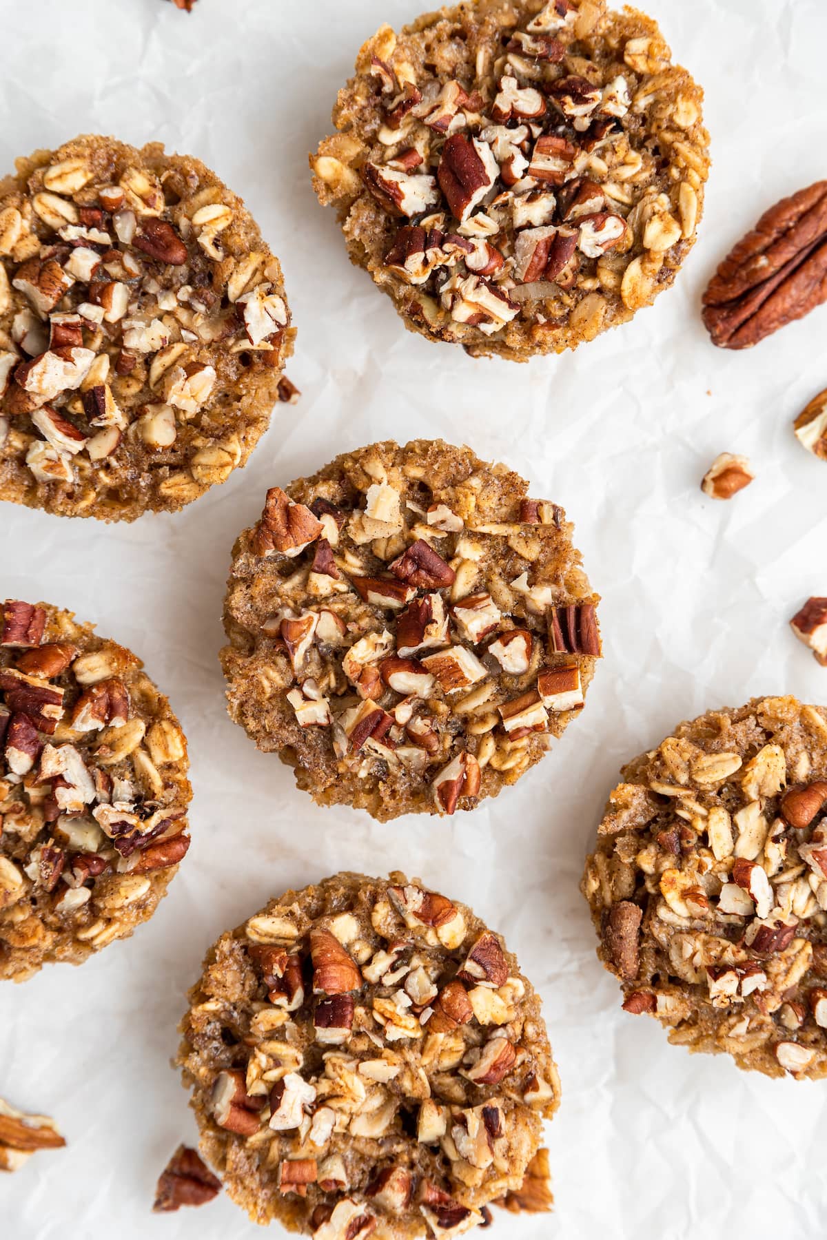 Six chai baked oatmeal cups on a piece of parchment paper.