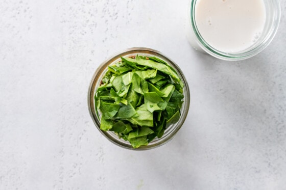 A glass jar with spinach.