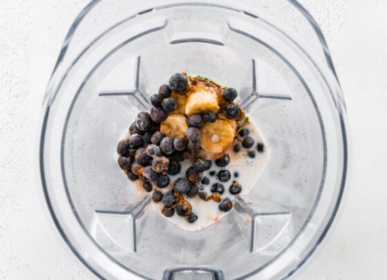 Ingredients for the chocolate blueberry smoothie in a blender before being blended.