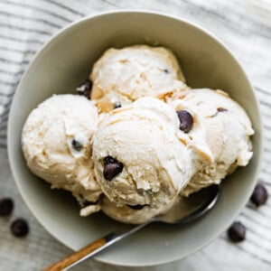 Scoops of cottage cheese ice cream in a bowl served with a spoon.