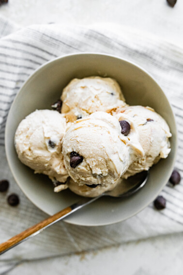 Scoops of cottage cheese ice cream in a bowl served with a spoon.