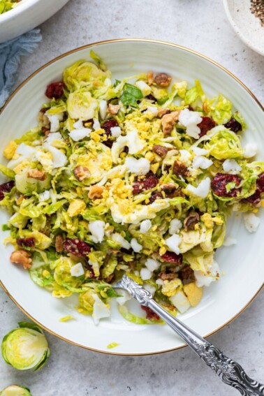 A white plate with a serving of the Brussels sprout chopped salad.