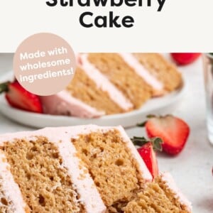 A slice of strawberry cake on a small white plate with a metal fork holding a piece of the slice.