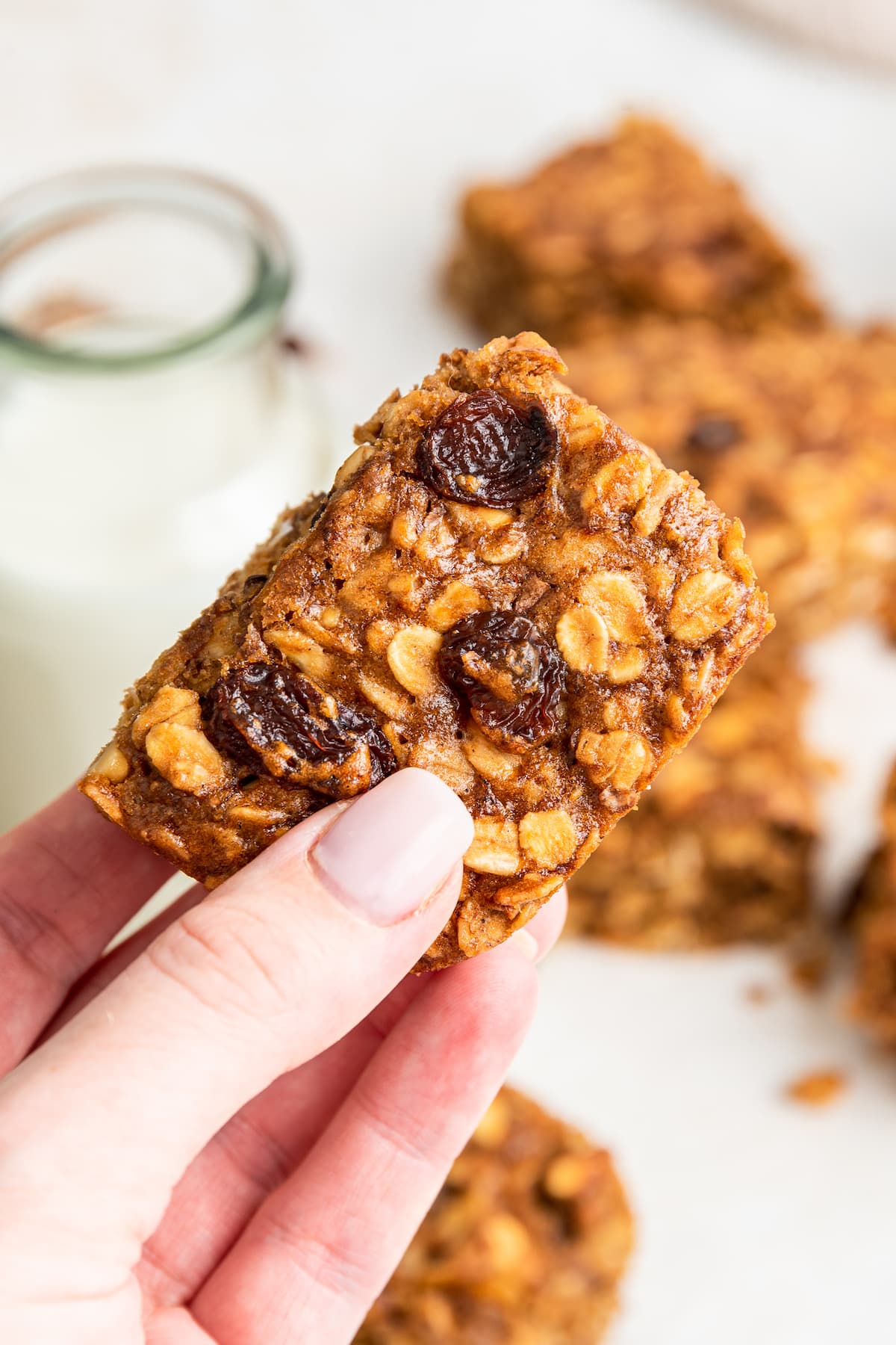 A woman's hand holding a banana oat bar.