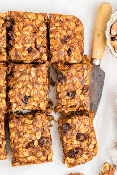 Six healthy banana oat bars with a metal serving spatula underneath one.