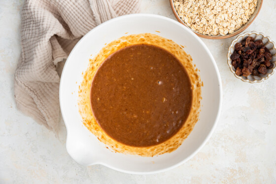 A large white bowl with the combined wet ingredients for the healthy banana oat bars.