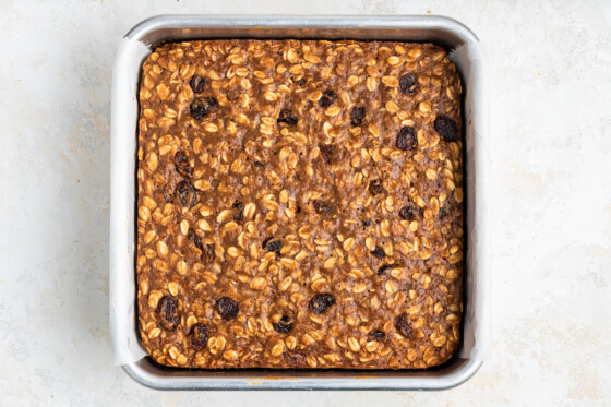 A square baking dish containing baked uncut banana oat bars.