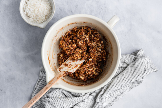 A large white mixing bowl, no-bake chocolate coconut bar mix, and a silicone spatula.