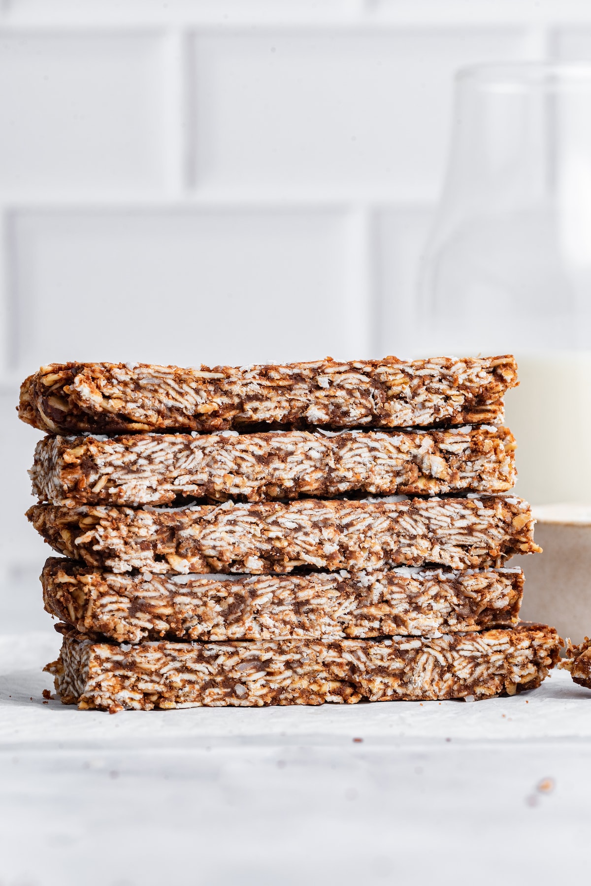 Five no-bake chocolate coconut bars stacked on one another.