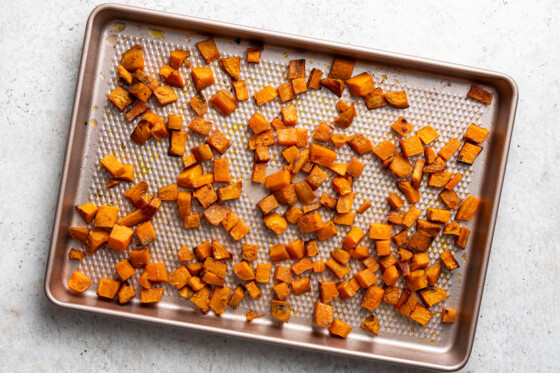 Cubed baked sweet potato on a baking tray.
