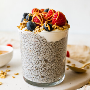 One protein chia pudding jar topped with fresh raspberries, blueberries, blackberries, greek yogurt and a drizzle of nut butter.