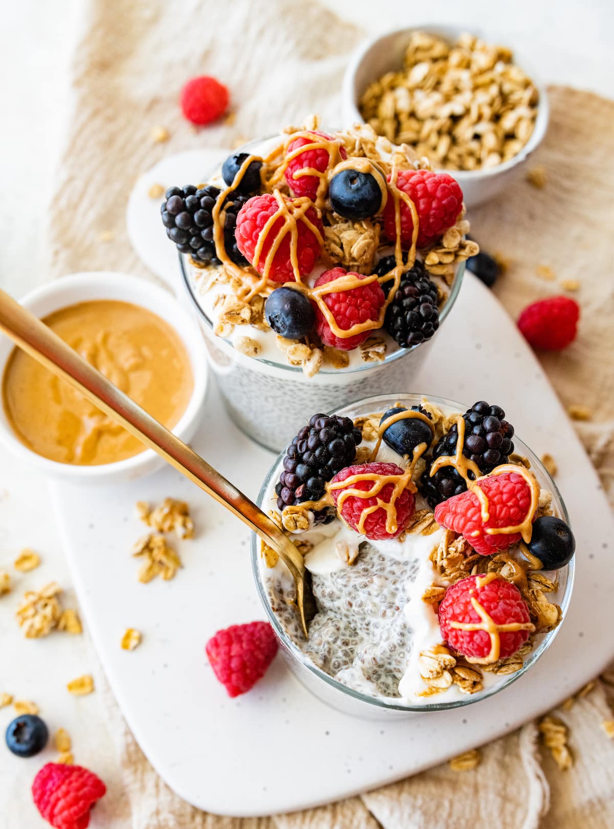 Two jars of protein chia pudding, one with a bite removed and a spoon.