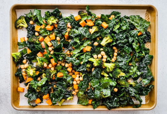 A baking tray with roasted sweet potato, kale, broccoli, and chickpeas.