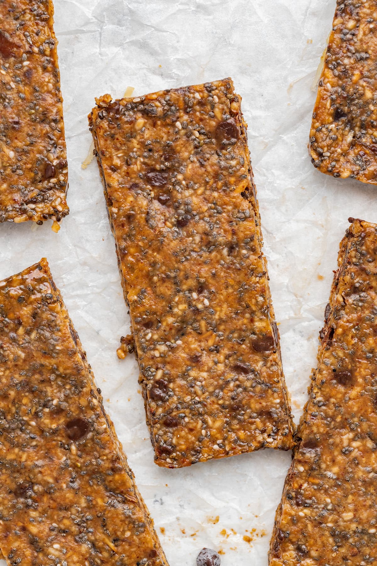 A close-up of a toasted coconut chia bar near four more.