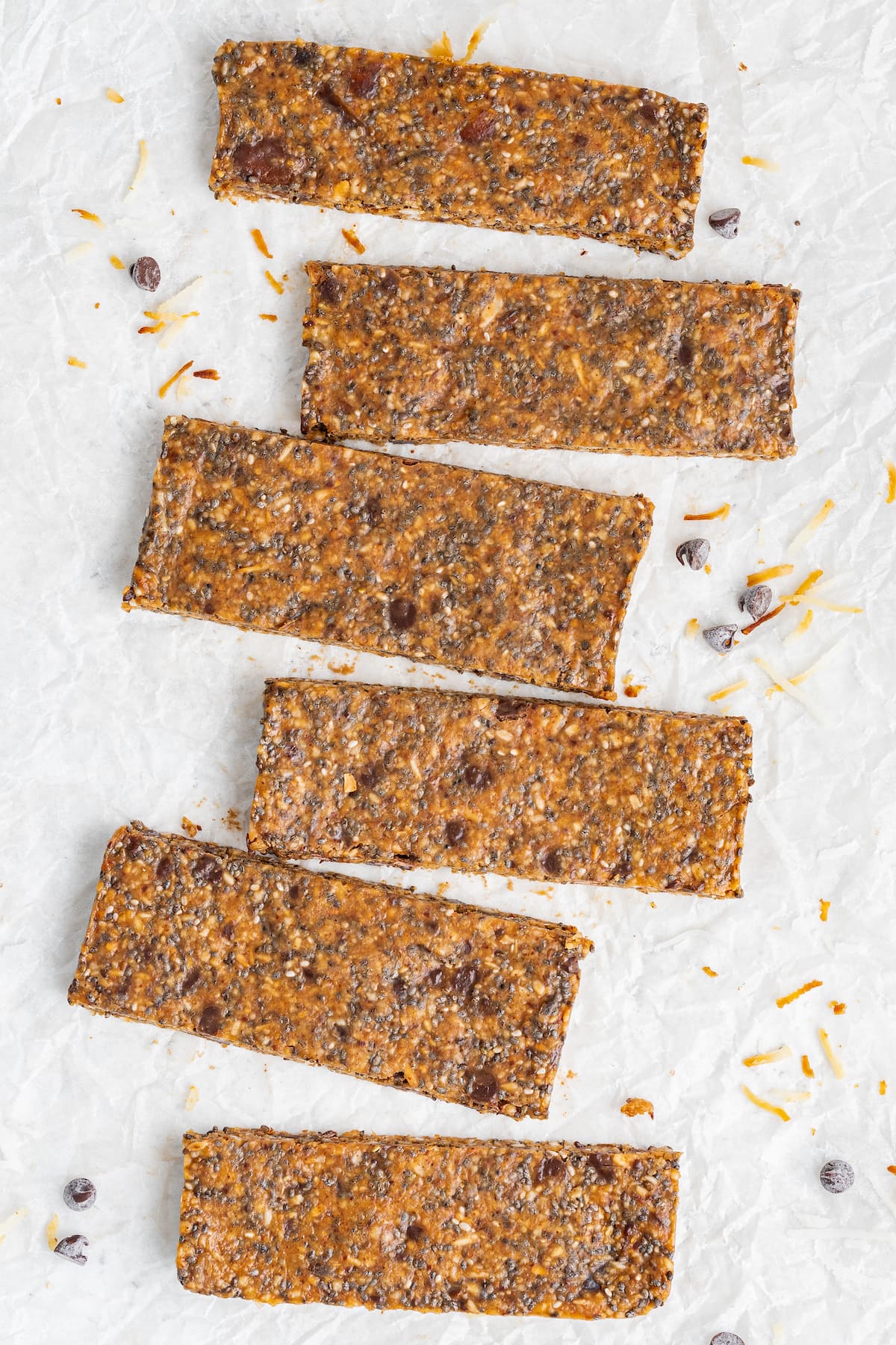Six toasted coconut chia bars on parchment paper.