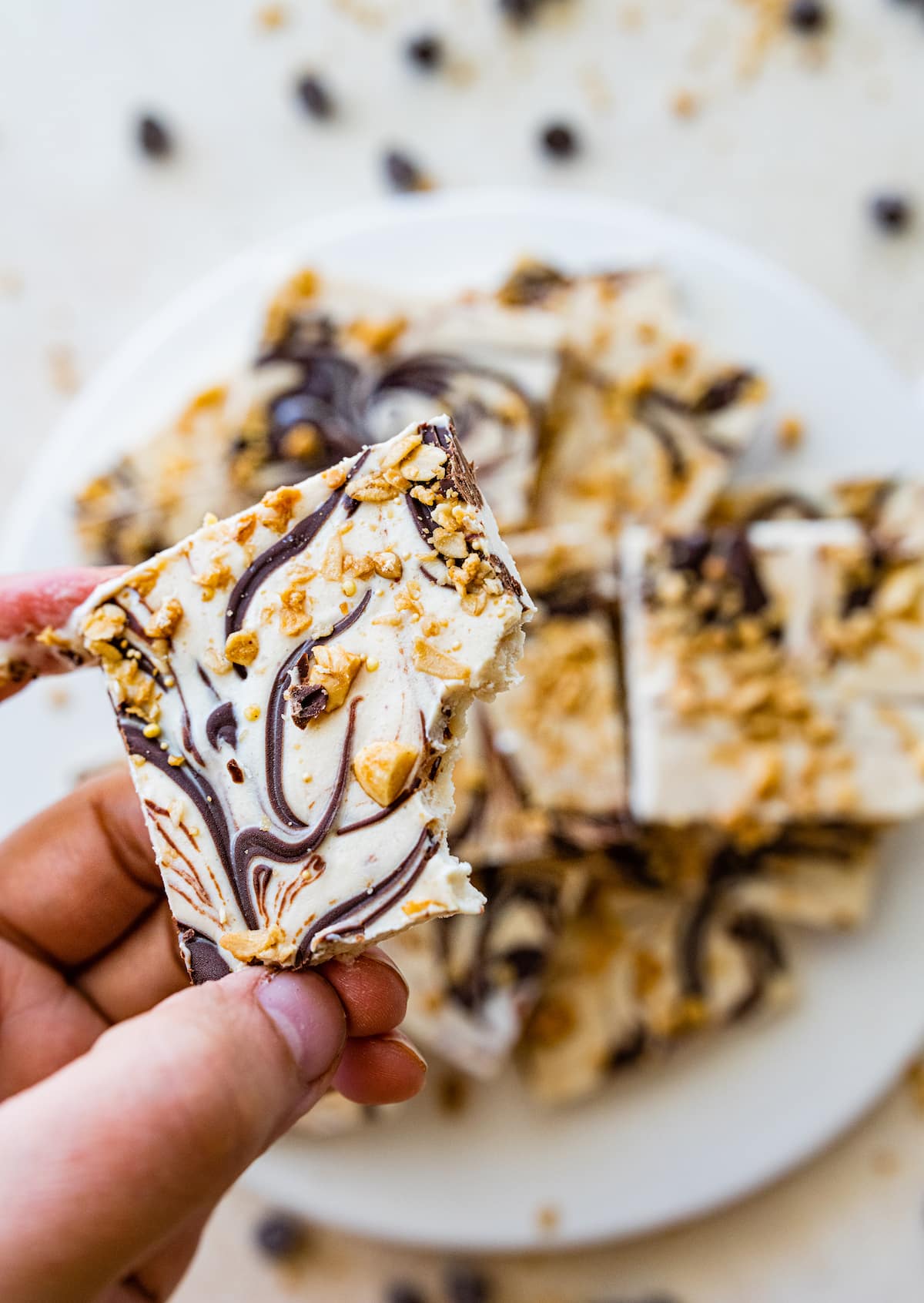 A woman's hand holding a piece of frozen cottage cheese bark.