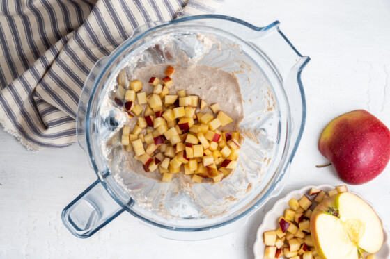 Diced apples in a blender with pancake batter.