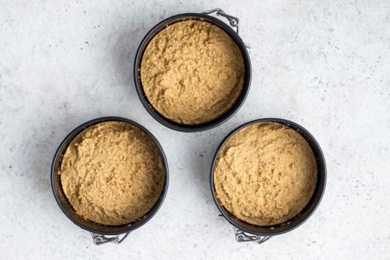 Three 4" round pans with smash cake batter in them after they've been baked.