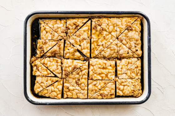 Tempeh cut into triangles marinating in a rectangular dish.