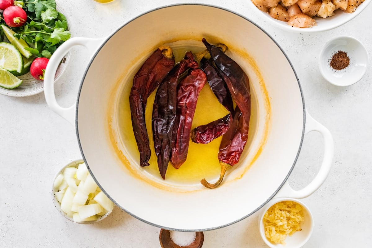 Five dried Chile peppers in a large white bowl.