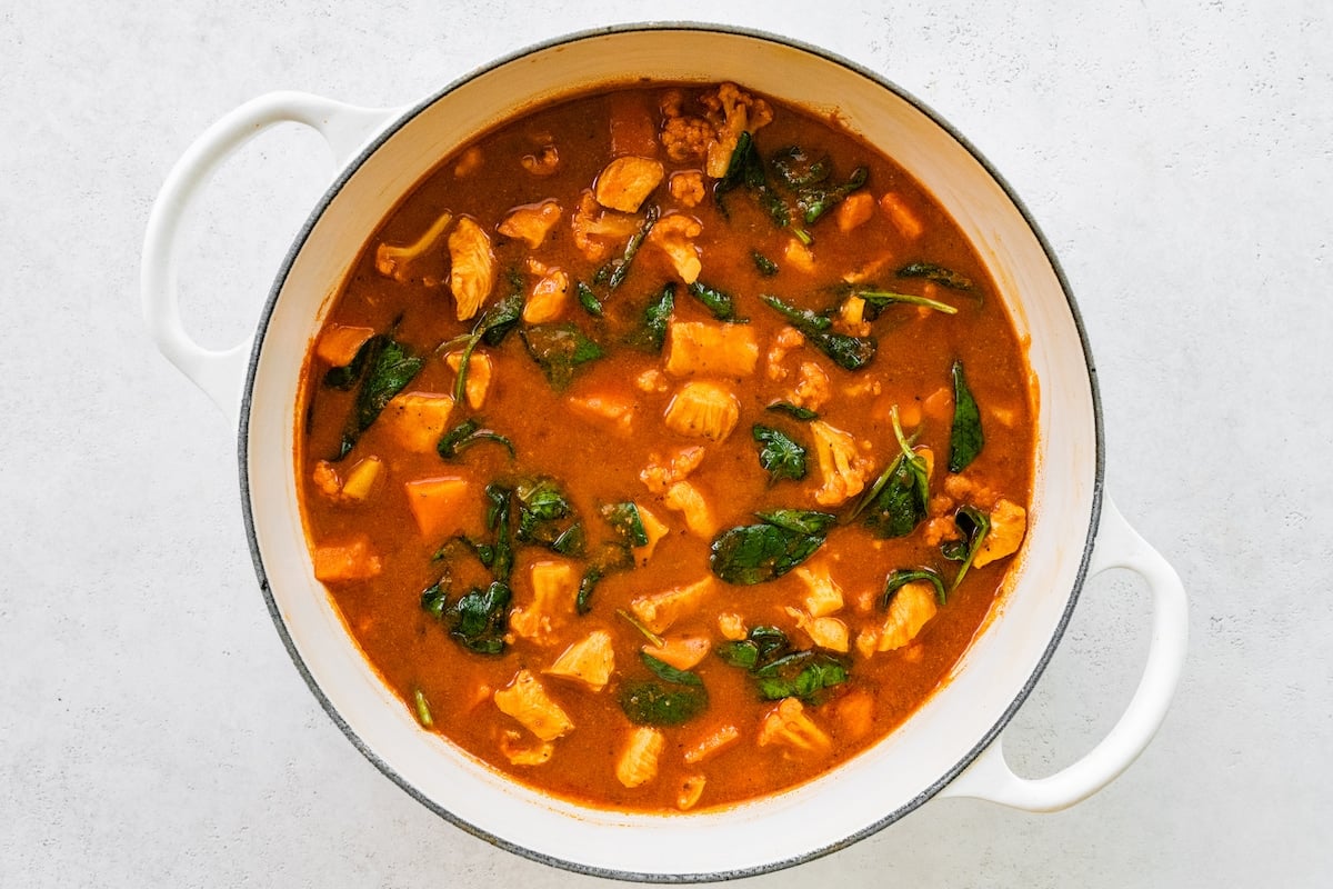 A large white pot with a Mexican sweet potato chicken soup.