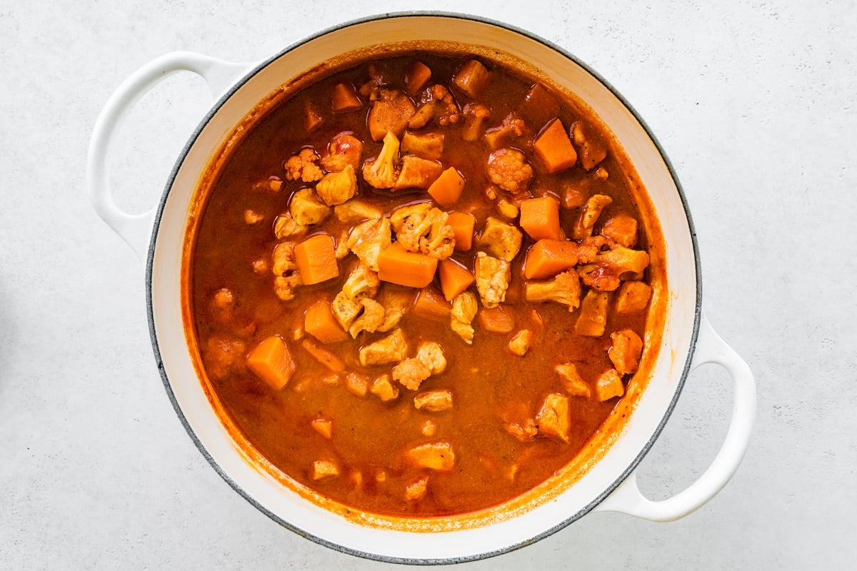 A large white pot with a Mexican sweet potato chicken soup.