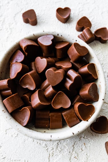 Heart-shaped poop chocolates in a small white bowl.