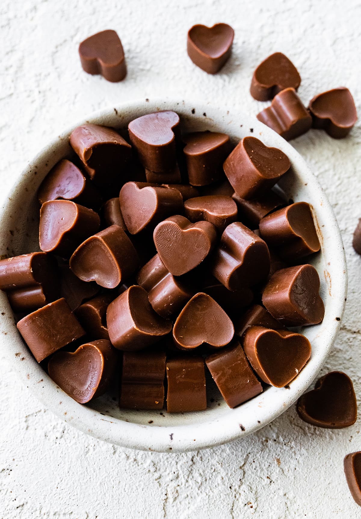 Heart-shaped poop chocolates in a small white bowl.