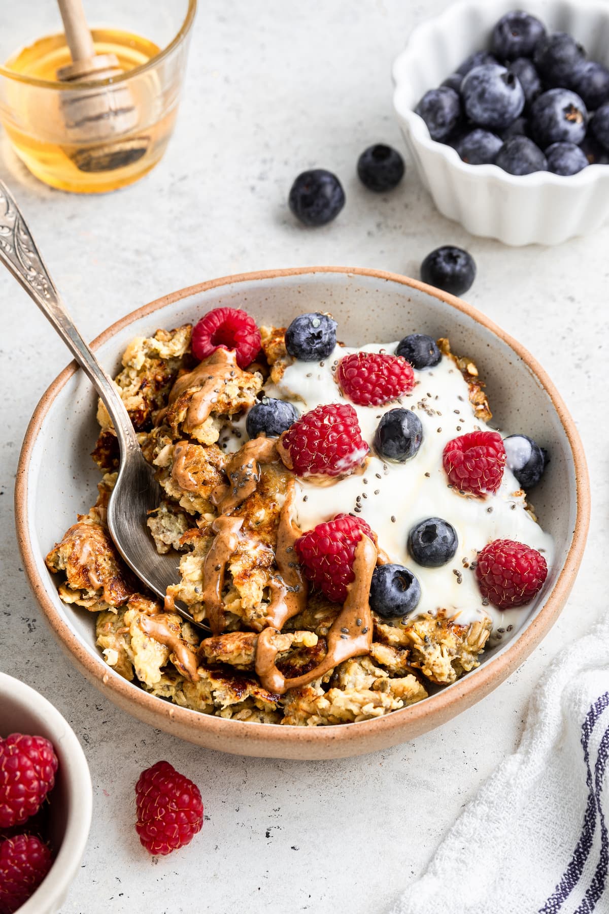 A bowl of scrambled oats with a metal spoon.