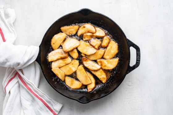 The apples cooking on a cast iron pan for the apple dutch baby.