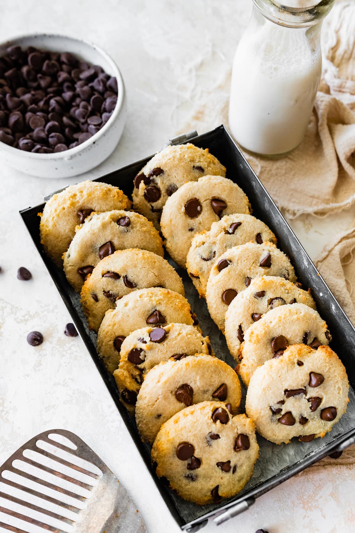 Fourteen cottage cheese chocolate chip cookies in a metal tin container.