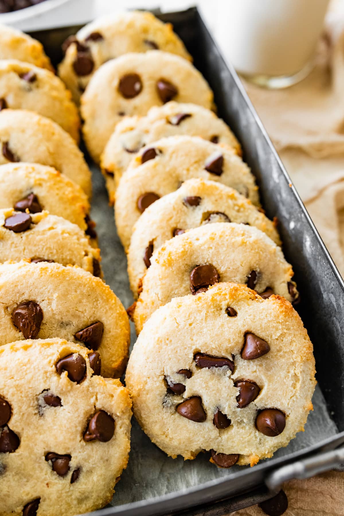 Fourteen cottage cheese chocolate chip cookies in a metal tin container.