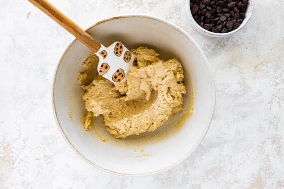 Cottage cheese cookie dough in a large white bowl with a silicone spatula.