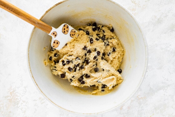 Cottage cheese chocolate chip cookie dough in a large white bowl with a silicone spatula.