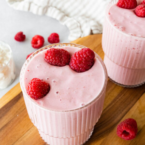 Two cottage cheese smoothies topped with fresh raspberries.