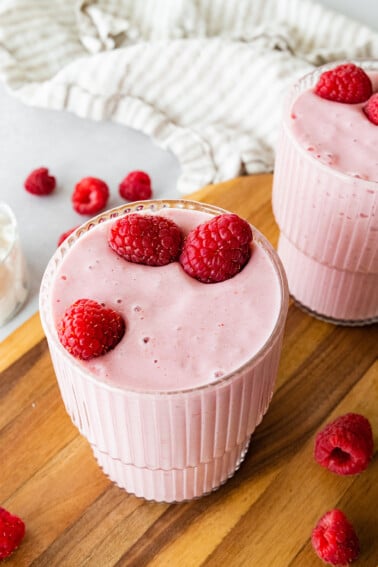 Two cottage cheese smoothies topped with fresh raspberries.