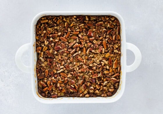 Baked oatmeal in a square white baking dish after it's been baked.