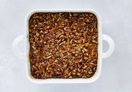 Baked oatmeal in a square white baking dish after it's been baked.