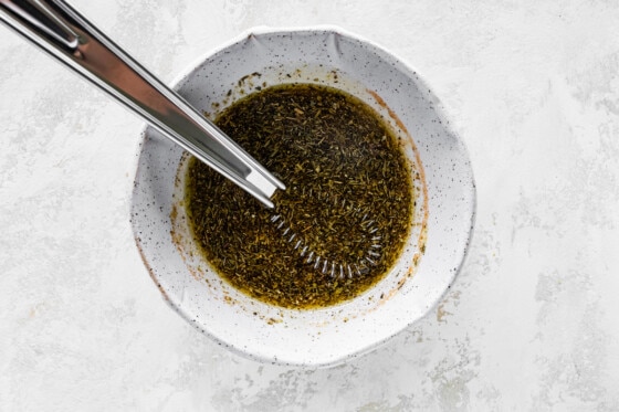 A bowl of marinade with a metal whisk.