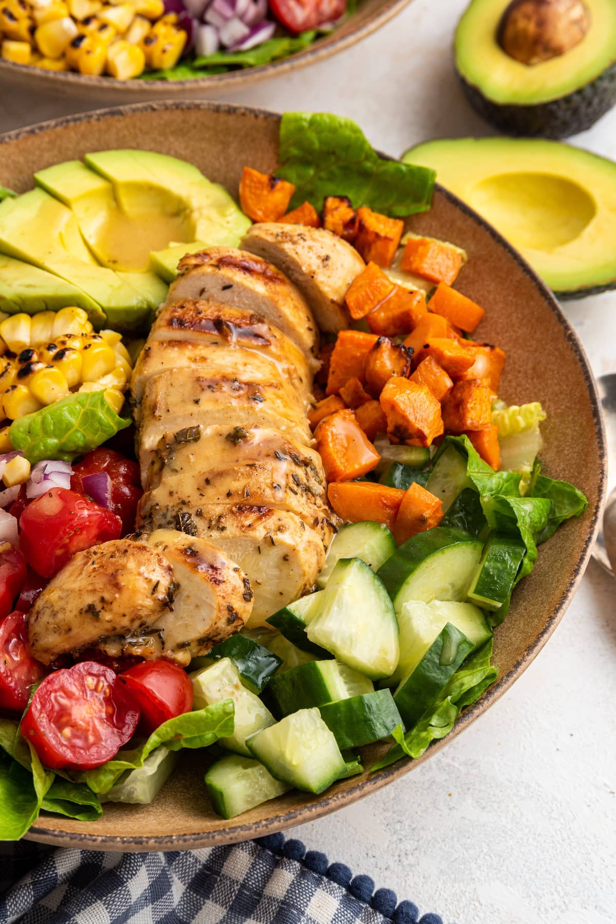 A close-up image of grilled chicken salad in a shallow bowl.