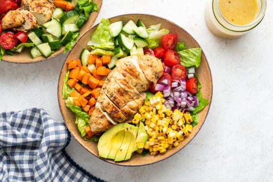 A serving of grilled chicken salad in a large shallow bowl.