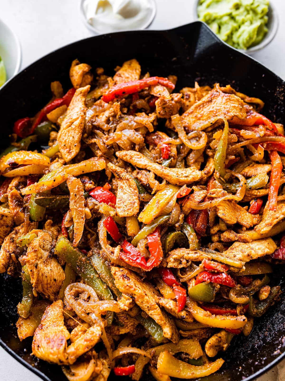 Chicken fajitas in a cast iron skillet.