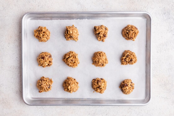 Oatmeal breakfast cookies formed into balls on a baking tray before being baked.