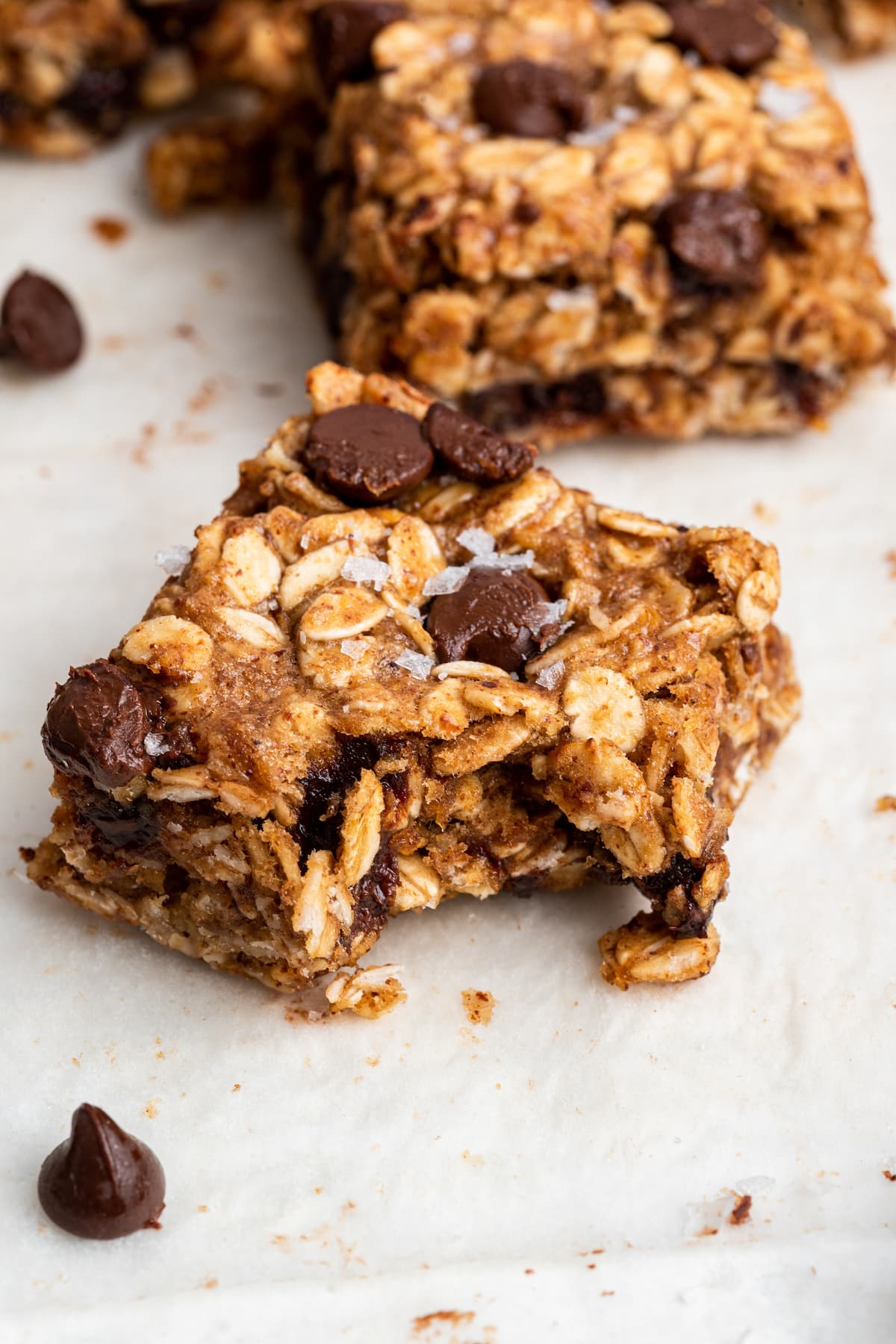 A oatmeal chocolate chip bar with a bite taken from it.