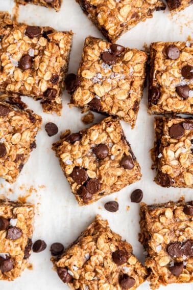Multiple oatmeal chocolate chip bars on parchment paper.