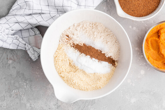 All the dry ingredients for the healthy pumpkin cake in a large mixing bowl.