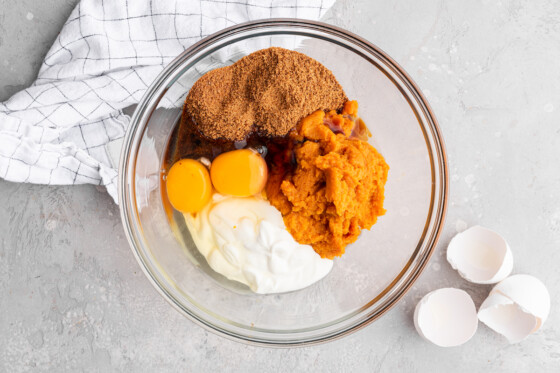 All the wet ingredients for the healthy pumpkin cake in a large glass mixing bowl.