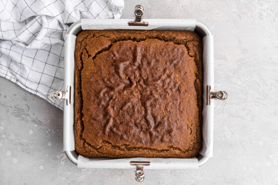 The healthy pumpkin cake after being baked in a square baking dish.