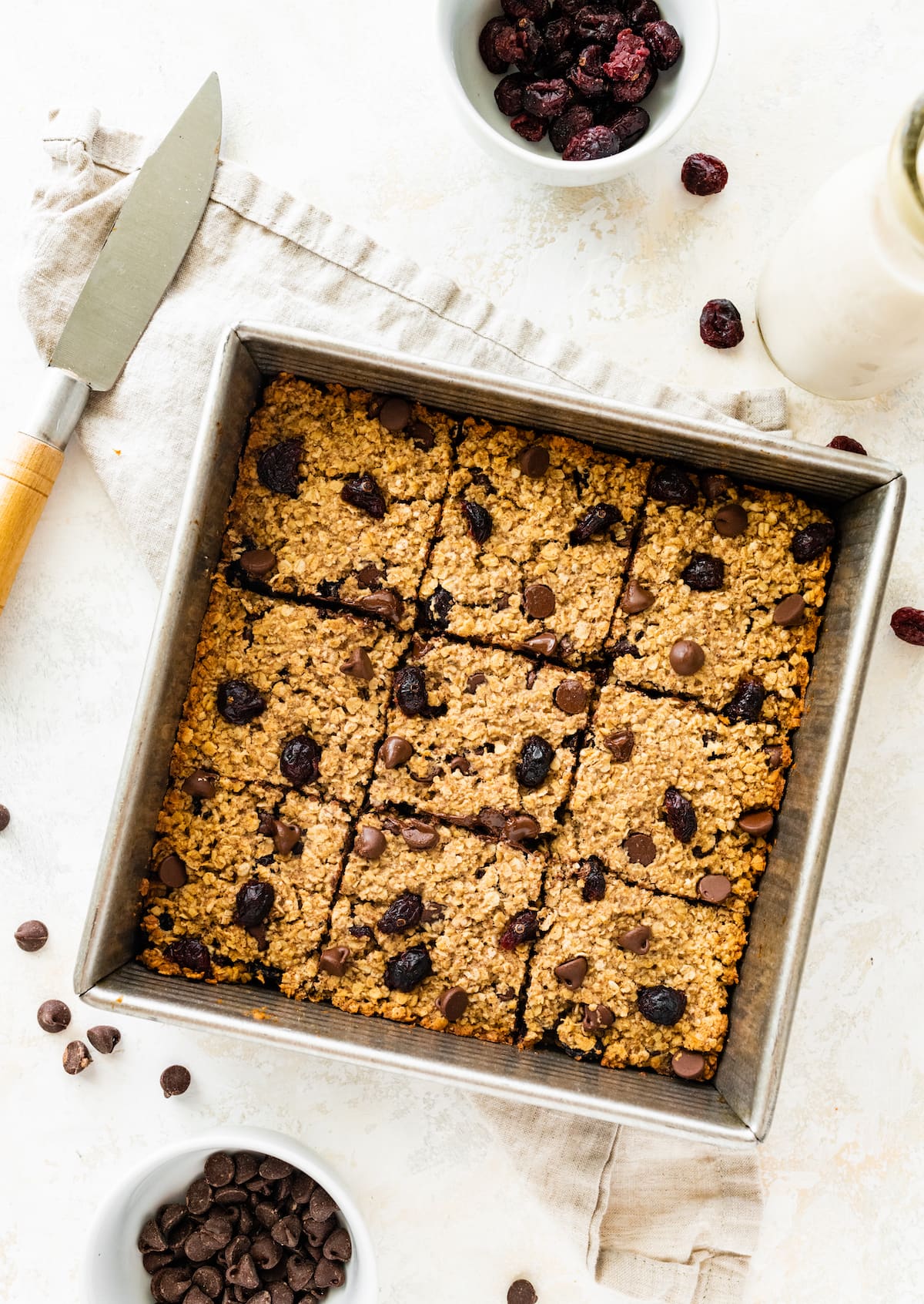 Oatmeal breakfast bars cut into squares, in a square baking pan.