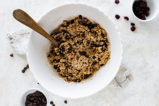 Dough for the oatmeal breakfast bars in a large mixing bowl with a large wooden spoon.